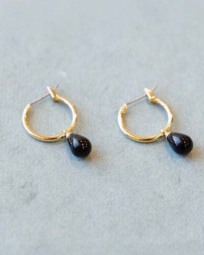 Downeast hoop and charm earrings featuring circular hoops with small hanging charms, stylish jewelry for everyday wear.