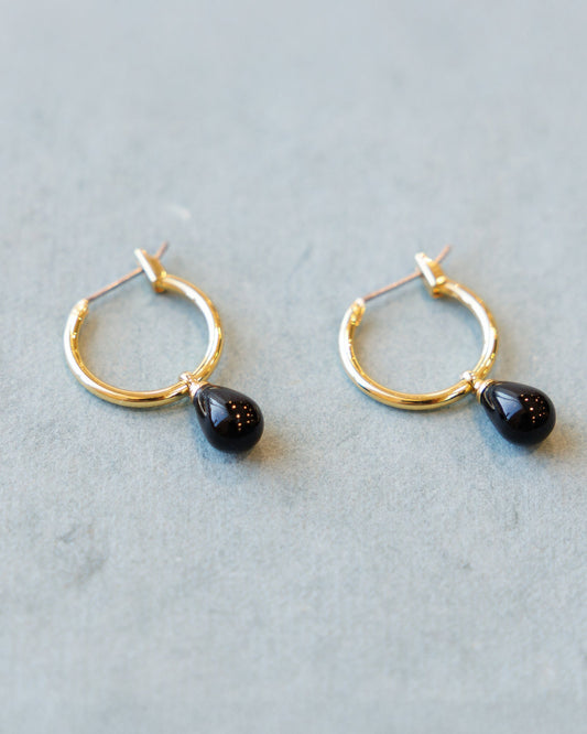 Downeast hoop and charm earrings featuring circular hoops with small hanging charms, stylish jewelry for everyday wear.