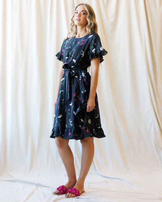 Downeast ruffle and wrap dress featuring flowing fabric, ruffled neckline, and tied waist for a stylish, feminine look.