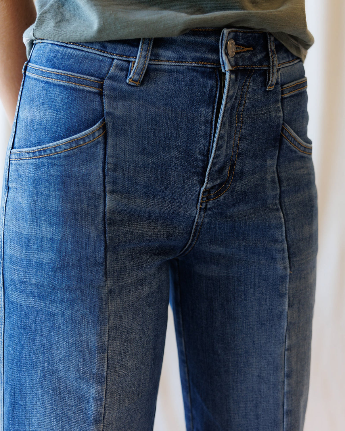 Downeast high rise seamed wide leg ankle denim jeans displayed on a hanger. Classic blue denim with visible seams and a relaxed fit.