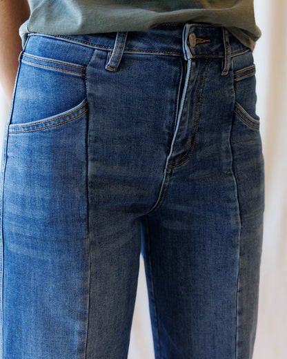 Downeast high rise seamed wide leg ankle denim jeans displayed on a hanger. Classic blue denim with visible seams and a relaxed fit.