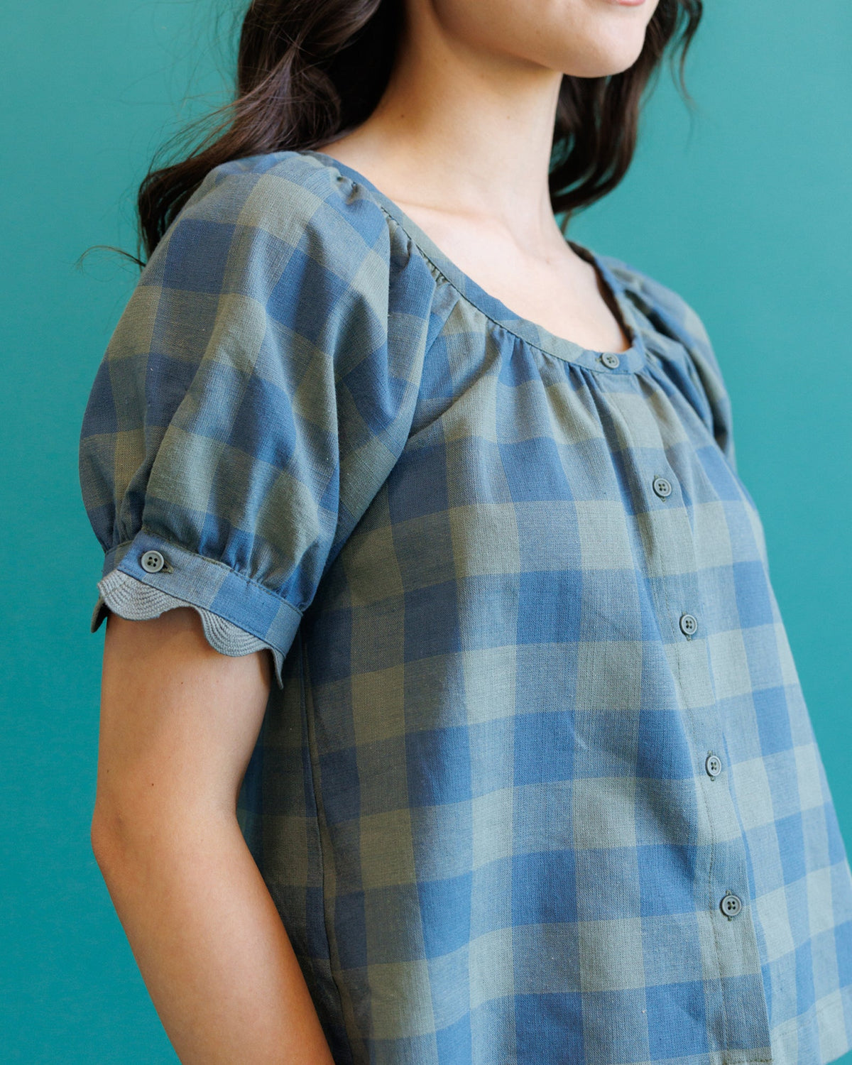 Downeast Checks Notes Top, casual women's blouse with checkered pattern and long sleeves, shown on a hanger.