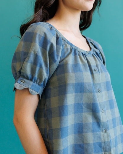 Downeast Checks Notes Top, casual women's blouse with checkered pattern and long sleeves, shown on a hanger.