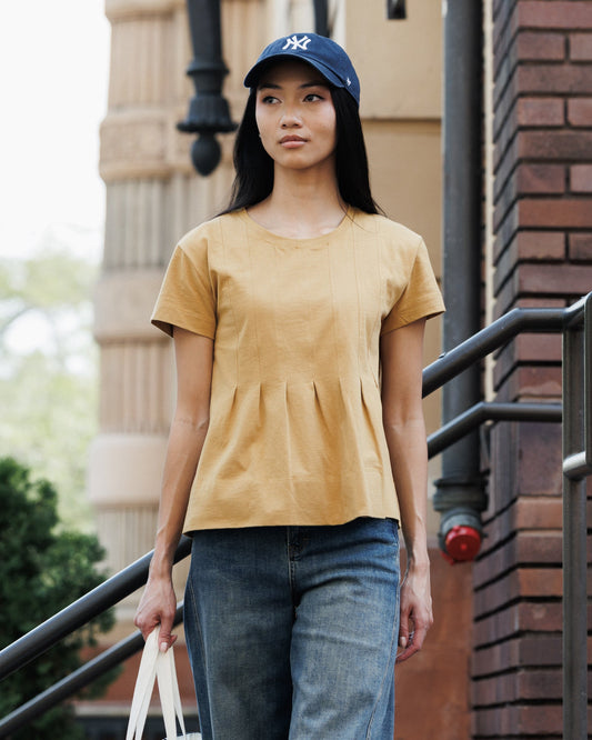 Downeast Portland peplum top in soft fabric with short sleeves and a fitted waist, styled on a hanger.