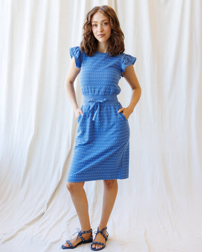 Downeast On Repeat Dress featuring a flowing, patterned fabric with a V-neck and short sleeves, displayed on a hanger.
