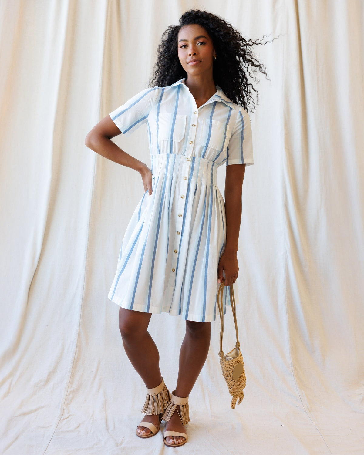 Downeast Seaside Stripe Dress displayed on a hanger, featuring blue and white nautical stripes, lightweight fabric, and casual summer style.
