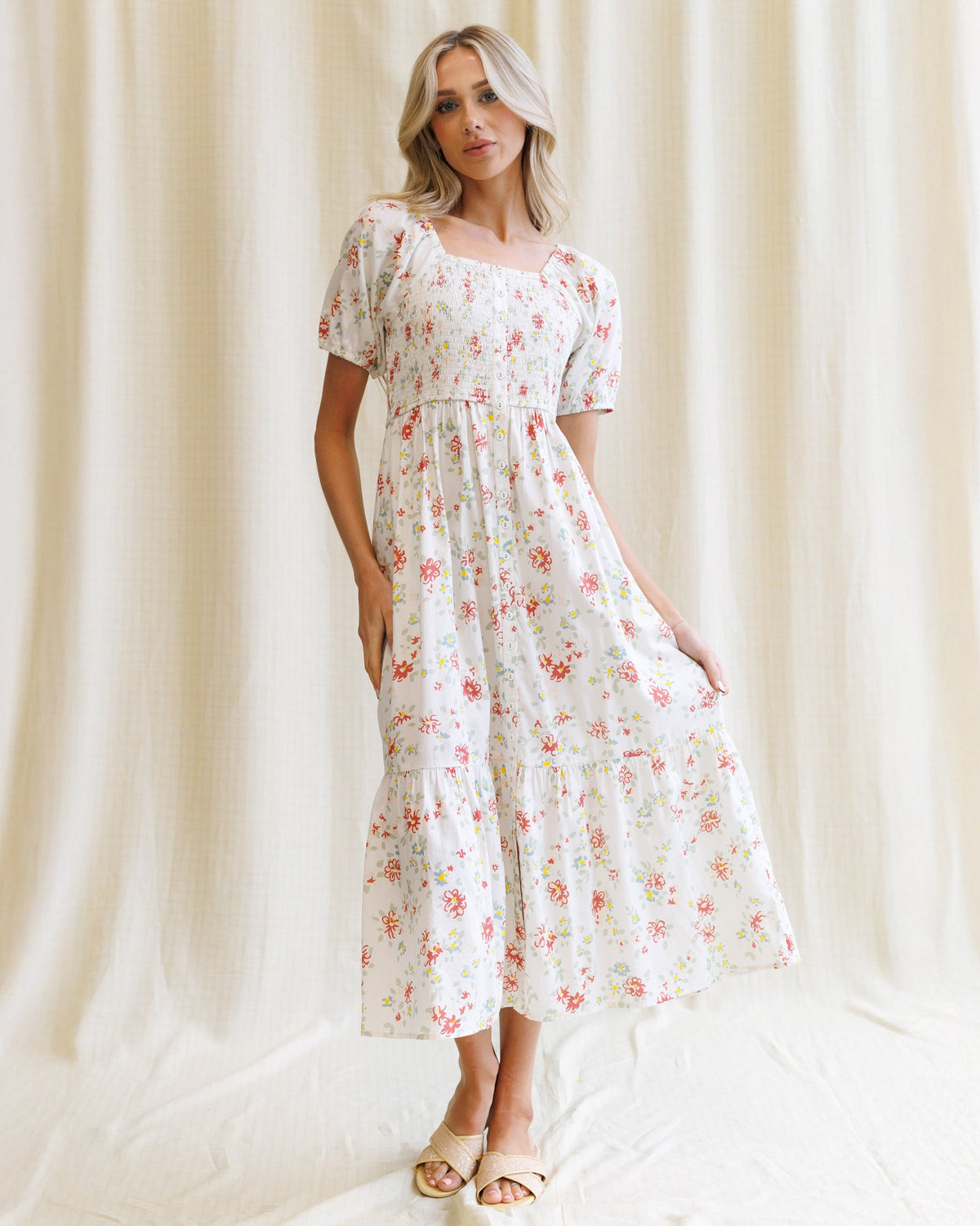 Downeast High Tea Dress displayed on a hanger showing floral fabric, fitted waist, and knee-length design.