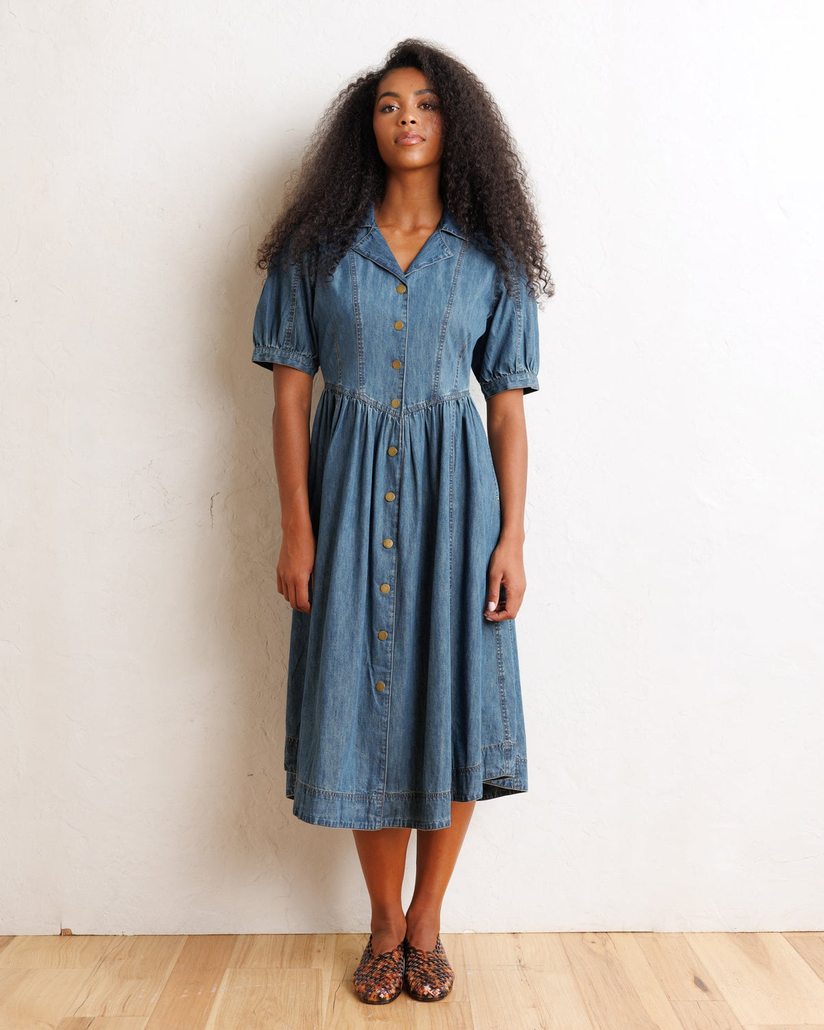 Downeast Orchard denim dress displayed on a hanger, featuring a casual fit with front pockets and rolled-up sleeves.
