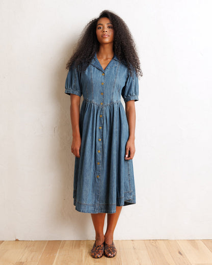 Downeast Orchard denim dress displayed on a hanger, featuring a casual fit with front pockets and rolled-up sleeves.
