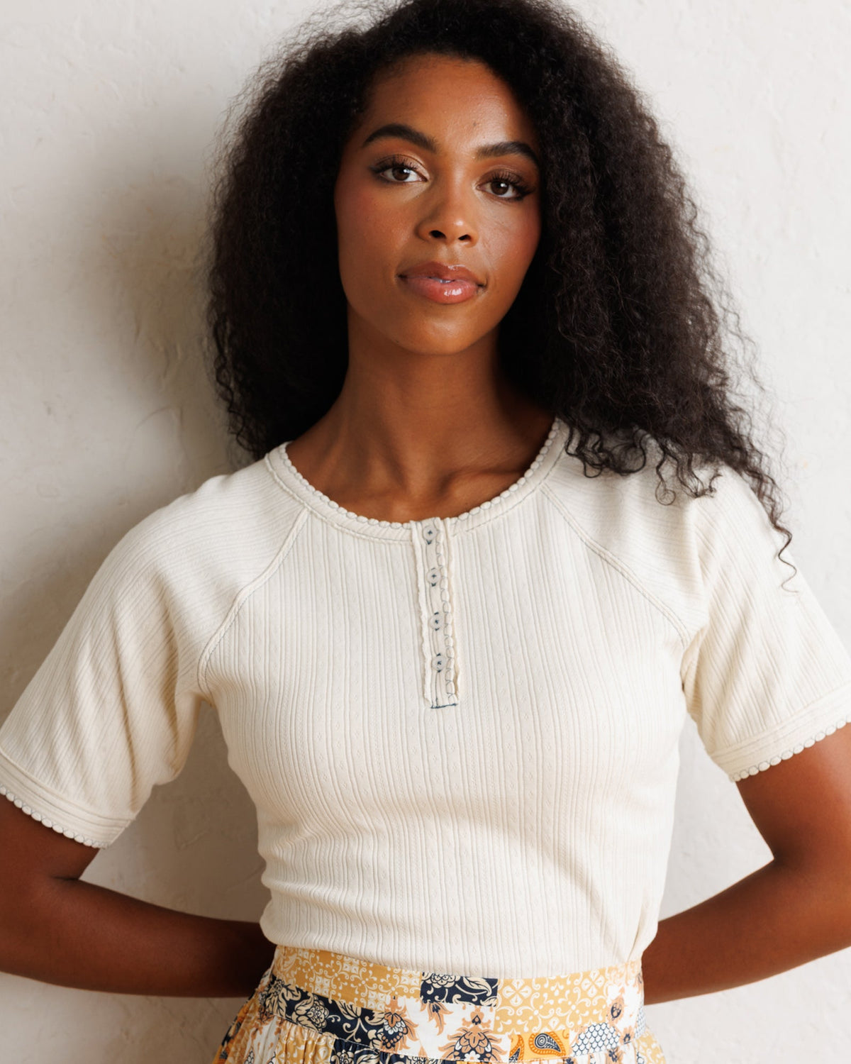 Downeast Pointelle Pretty Top, a stylish women's blouse with delicate knit pattern and soft fabric, displayed on a hanger.