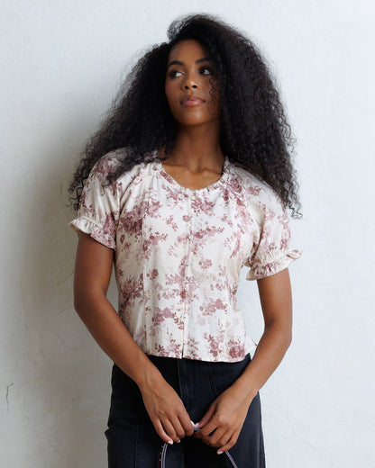 Downeast La Vie En Rose top, stylish women's blouse with floral pattern and short sleeves, displayed on a hanger.
