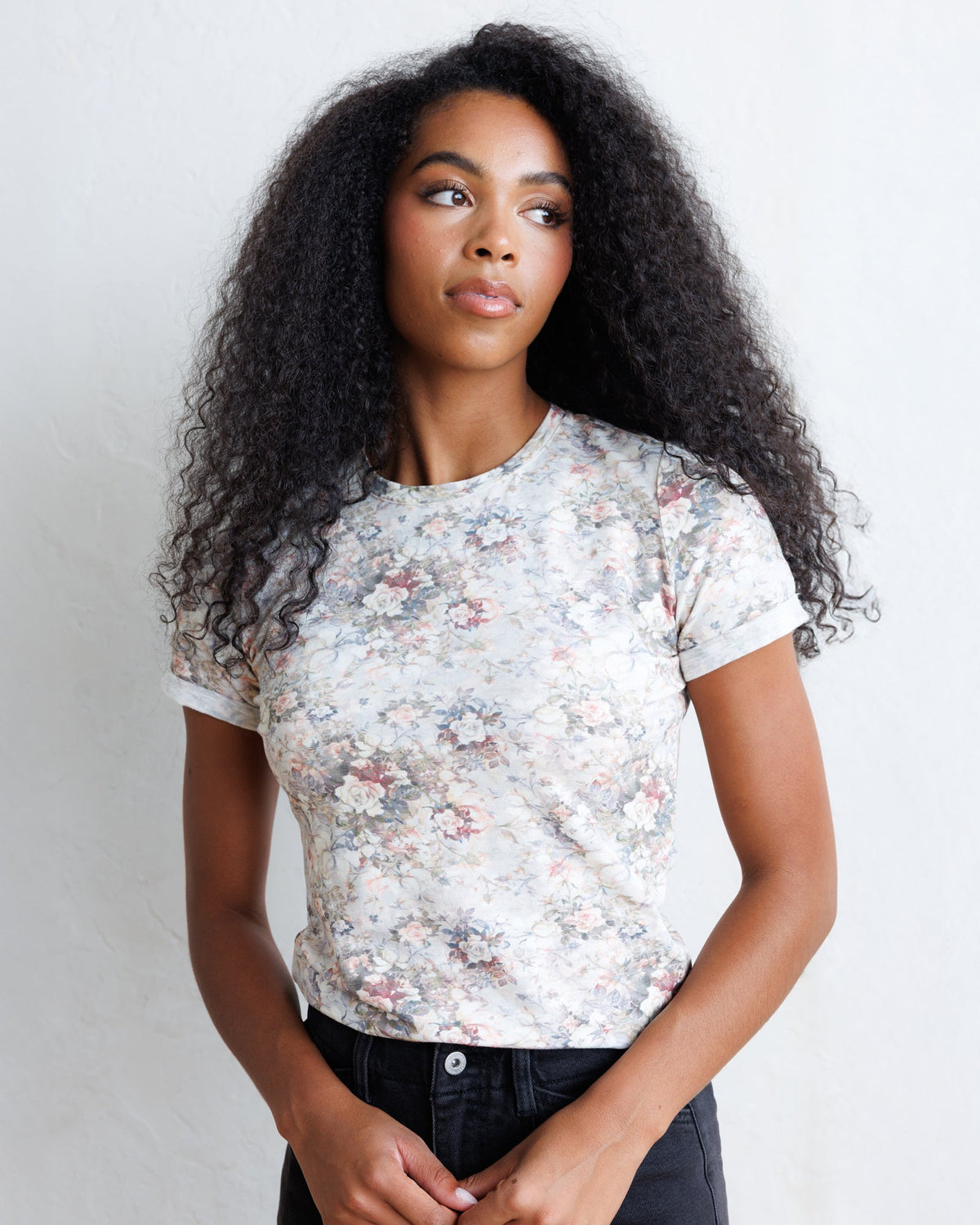 Downeast Go Floral Tee, a casual women's top with a vibrant floral print and short sleeves, displayed on a hanger.