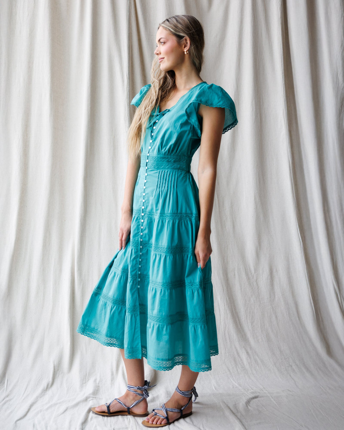 Downeast heirloom dress featuring intricate embroidery and vintage-inspired design, displayed on a hanger.
