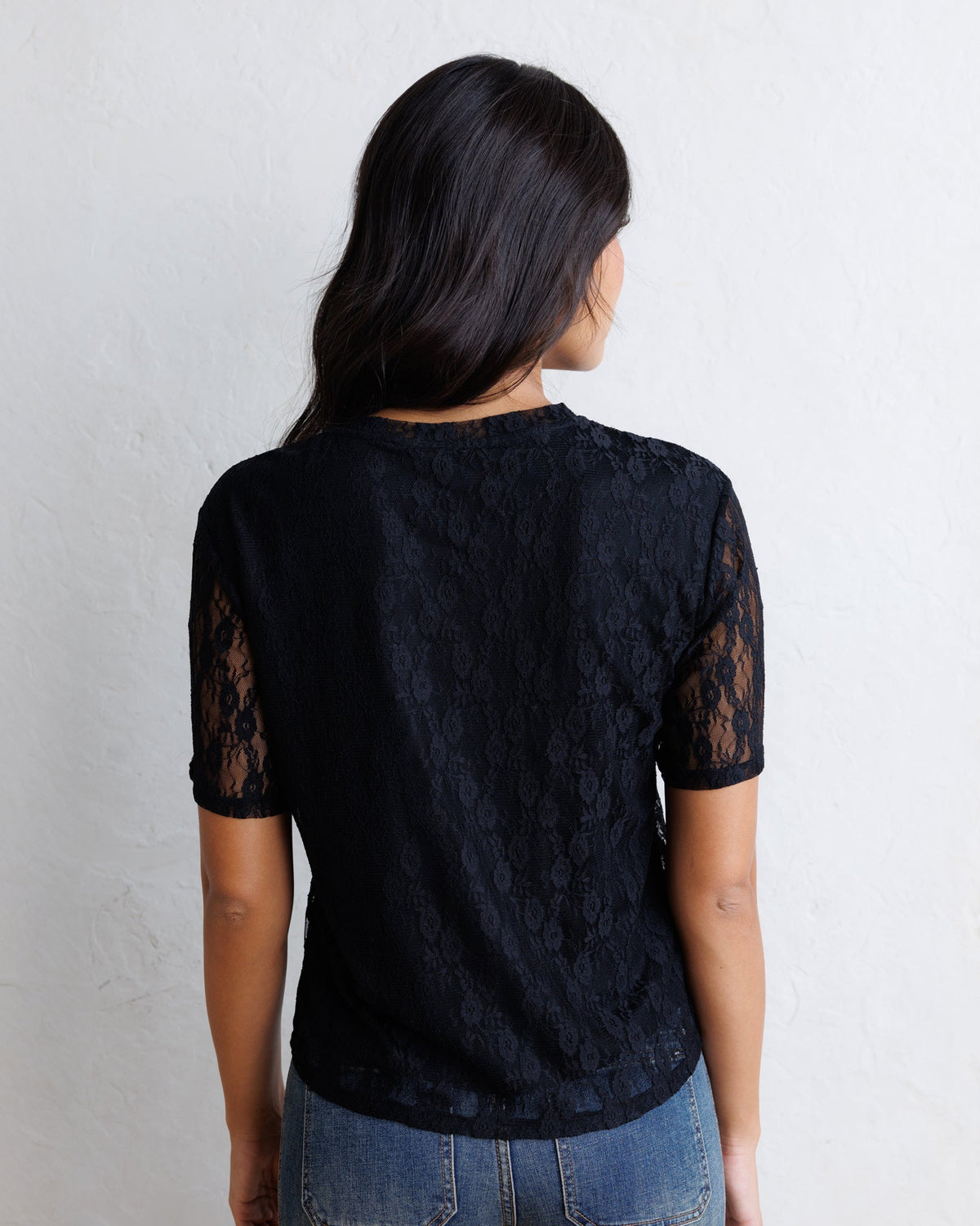 Light blue Downeast Laid Back Lace Tee top with delicate lace details and a relaxed fit, displayed on a hanger.