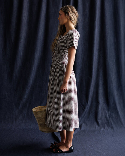 Downeast Maybelle Dress featuring a flowing fabric and floral pattern, showcased on a hanger against a neutral background.