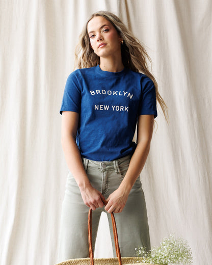 Downeast Brooklyn Tee, casual cotton top in a neutral color, displayed on a hanger with fabric texture visible.