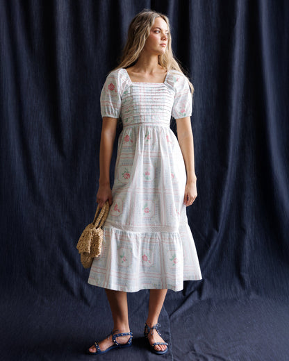 Downeast cross stitch crochet dress displayed on a hanger, showcasing intricate pattern and lightweight fabric.