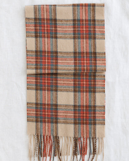 Downeast Golden Hour scarf with vibrant, warm-toned fabric displayed flat with fringed edges.