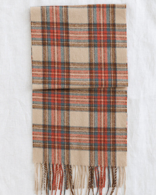 Downeast Golden Hour scarf with vibrant, warm-toned fabric displayed flat with fringed edges.