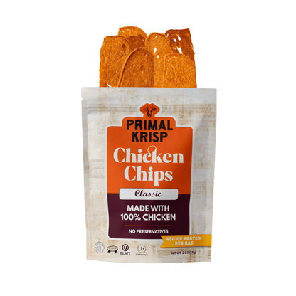 Primal Krisp Classic Chicken showing crispy, golden-brown breaded chicken fillet on a white plate.