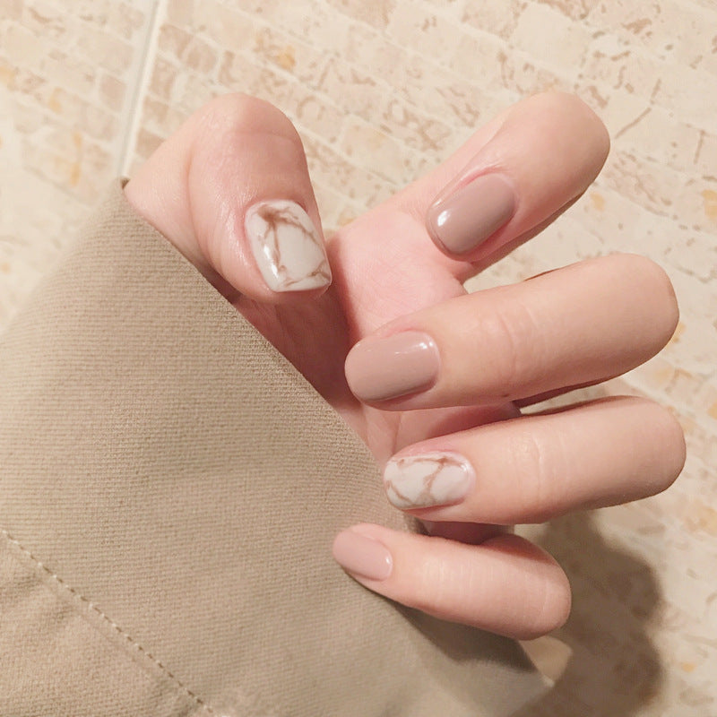 Light khaki smudge false nails displayed in a set