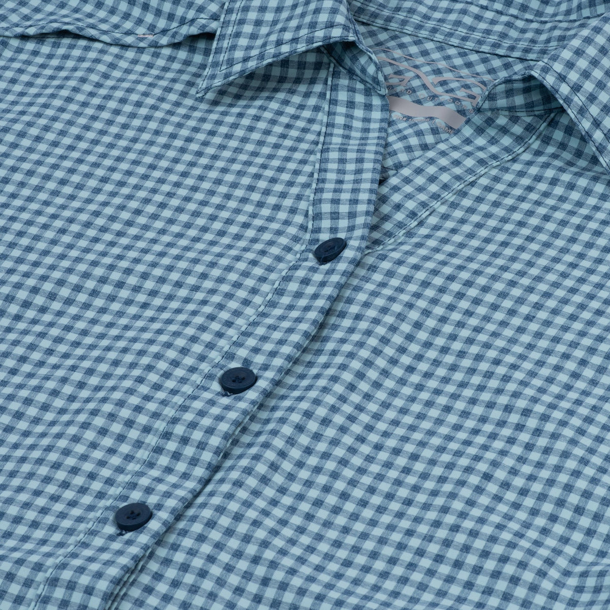 Sea glass ladies' TekCheck shirt by GameGuard, close-up of the plaid fabric and button details in natural lighting.