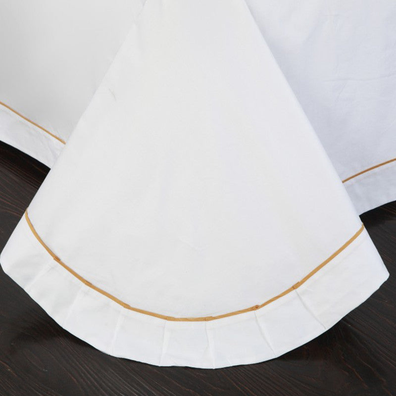 Four-piece cotton bedding set in soft fabric with fitted sheet, flat sheet, and pillowcases folded neatly