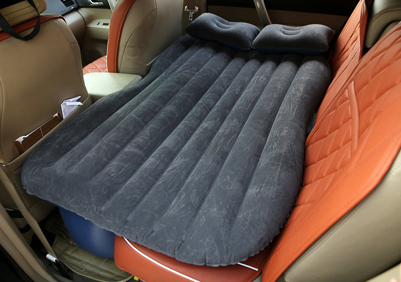 Inflatable car bed with cushioned surface and raised side bolsters for comfortable travel rest