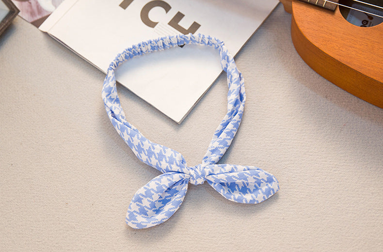 Big bow tie bunny ears headband in a playful design, shown from the front