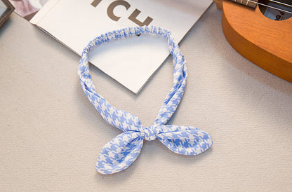 Big bow tie bunny ears headband in a playful design, shown from the front