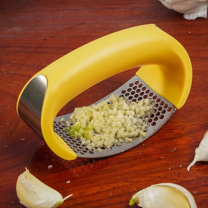 Stainless steel manual garlic press and masher with curved design for kitchen use