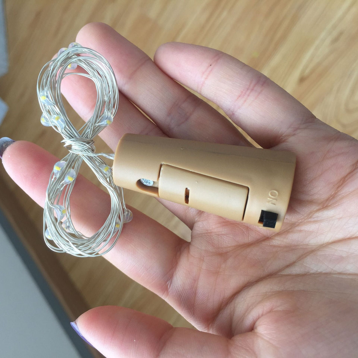 Button battery box LED light with compact battery compartment and LED illumination.