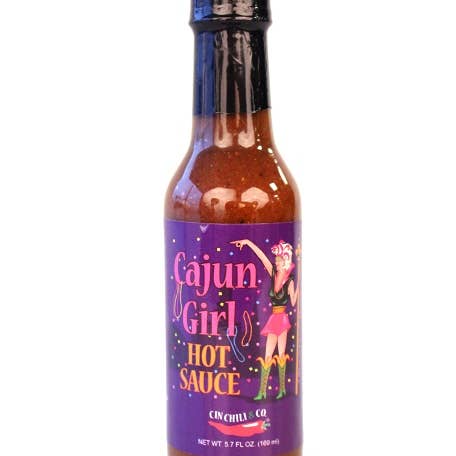 Cajun Girl Louisiana-Style Hot Sauce bottle by Cinderosa Ranch with red and yellow label and hot sauce inside