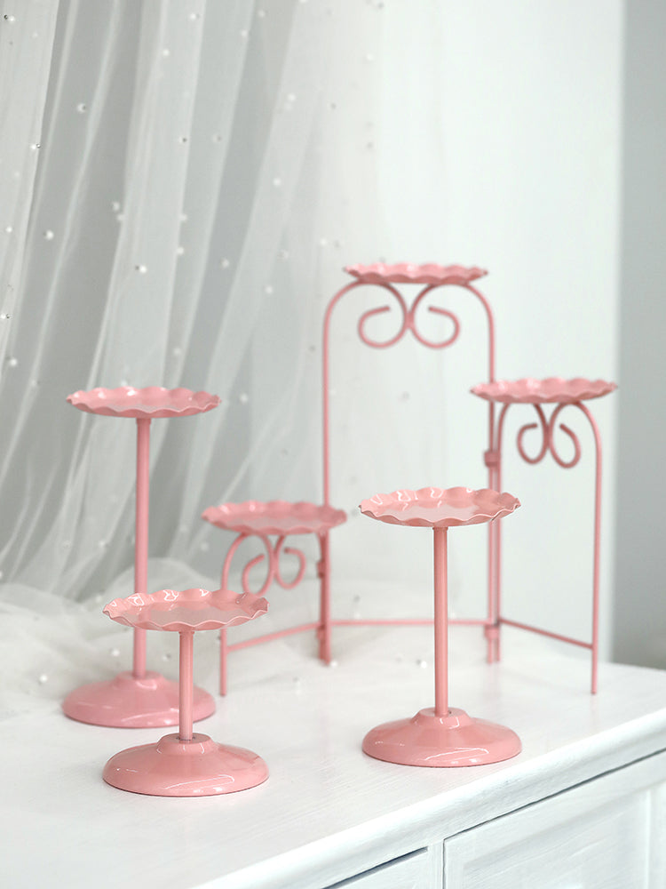 Pink wedding dessert table cake stand displaying a layered cake centerpiece