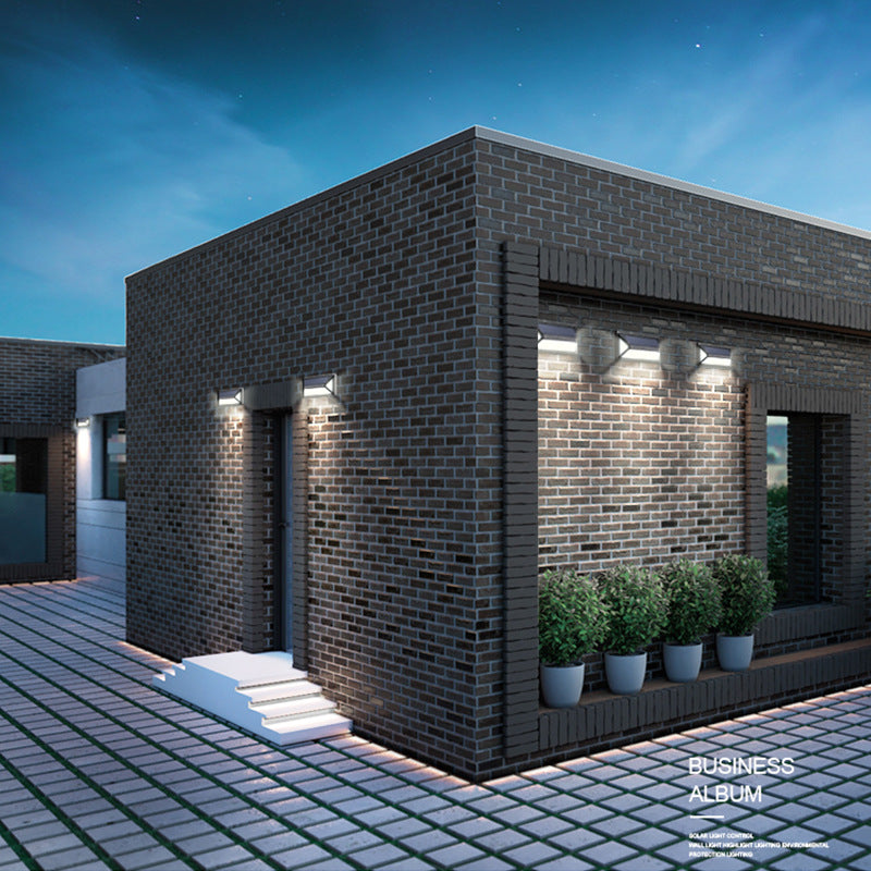 Solar wall light outdoor fixture mounted on a wall, featuring a compact modern design and integrated solar panel