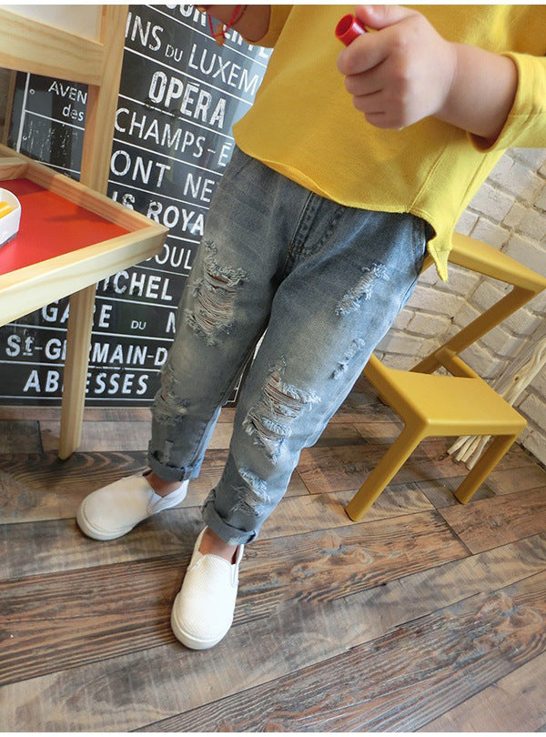 Korean style boys ripped trousers in a trendy distressed design
