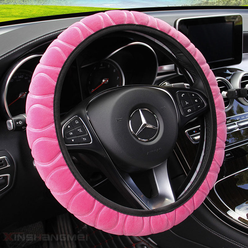 Plush car steering wheel cover in soft, textured fabric close-up