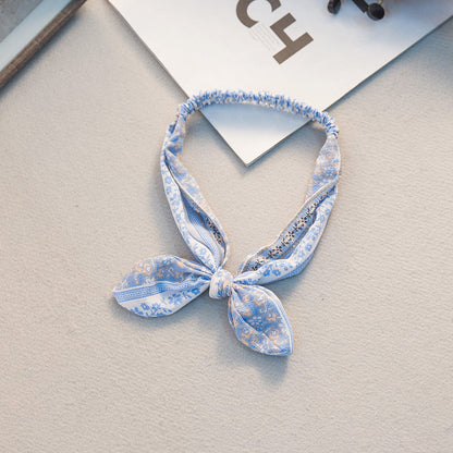Bunny ears headband with a large bow tie detail, shown in a playful design