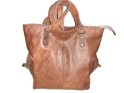 Handmade women's shoulder bag with a strap, featuring a textured leather surface and stylish design.