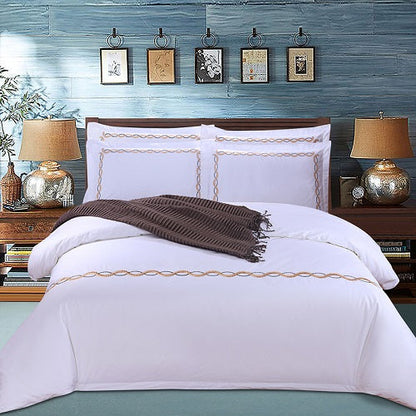 Four-piece cotton bedding set in white, featuring a soft textured duvet cover and matching pillowcases