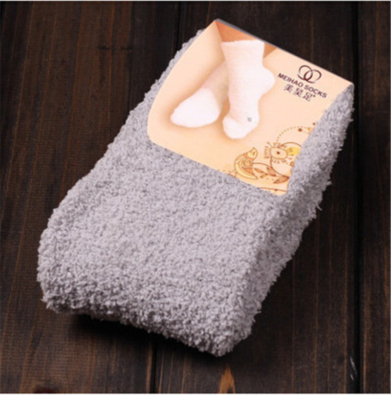 Warm feet on bed wearing household warm socks, cozy close-up view