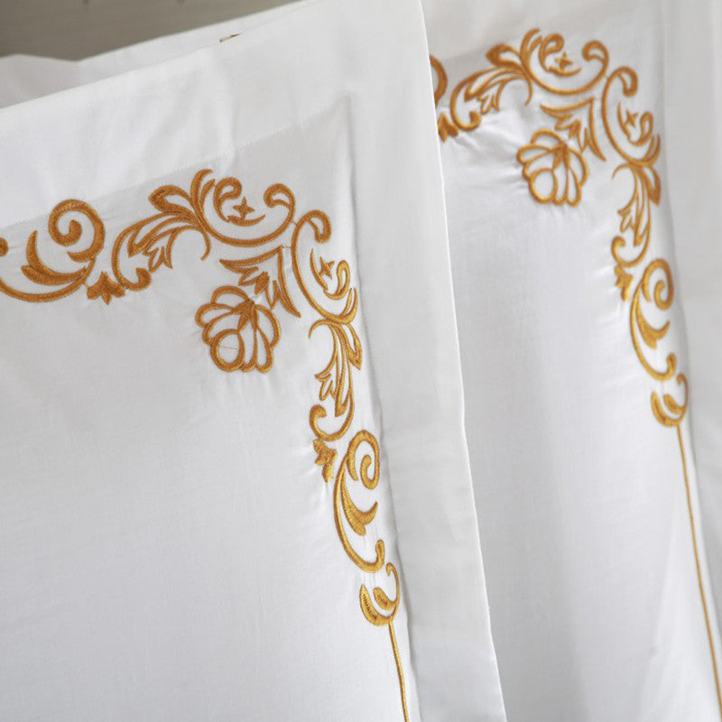 Four-piece cotton bedding set in soft fabric with coordinated sheets and pillowcases folded neatly