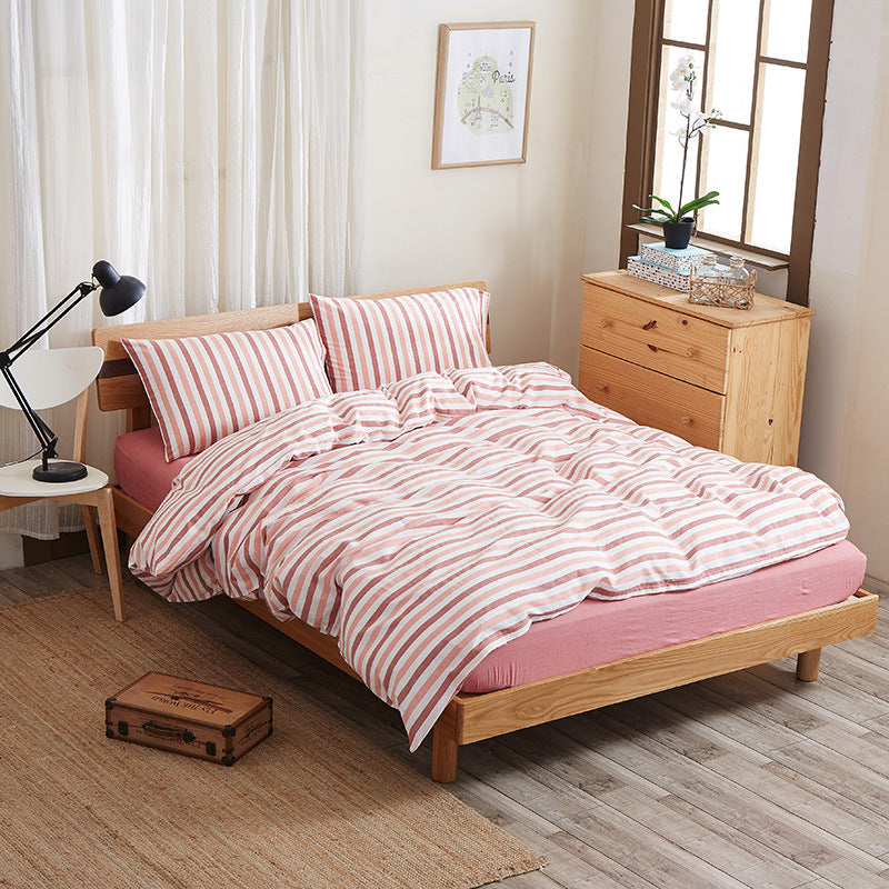 Pure cotton four-piece bed sheet set in a soft, neutral design neatly arranged on a bed