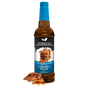 Bottle of Syruvia sugar-free caramel pecan syrup with a label and a dark caramel color liquid inside.
