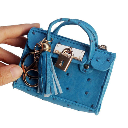 Leather solid color fashion tassel mini handbag with compact design and decorative tassel detail