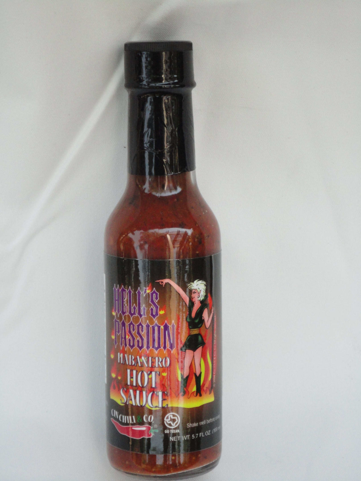 Cinderosa Ranch Hell's Passion Habanero Hot Sauce bottle with fiery red sauce and label featuring flames and habanero peppers.