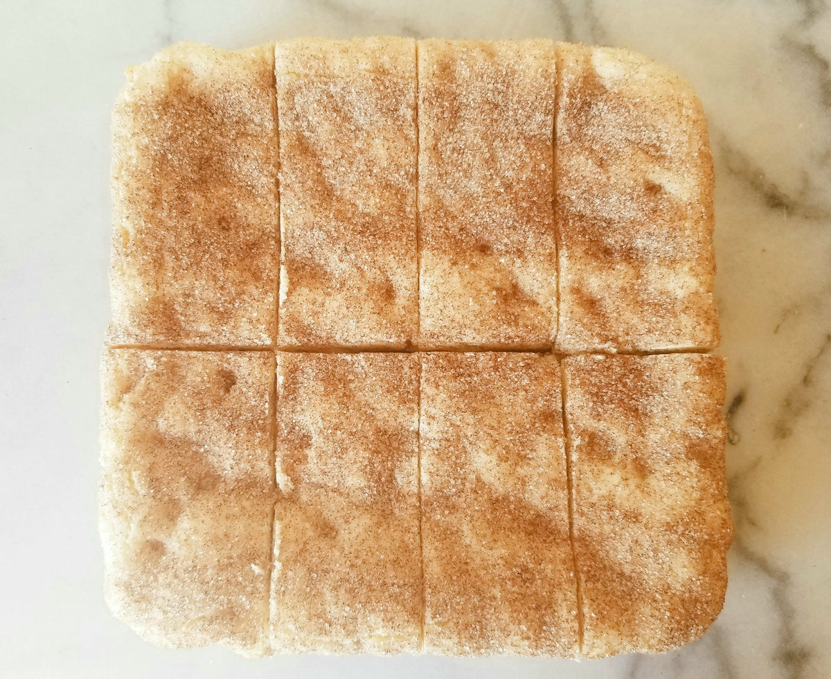 White chocolate snickerdoodle blondies from Let's Get Baked Artisan Desserts, featuring creamy white chocolate and cinnamon sugar topping.