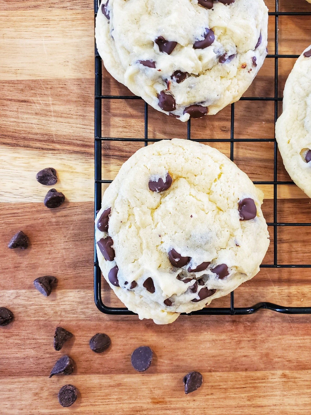 Freshly baked chocolate chip cookies from Let's Get Baked Artisan Desserts, arranged in a dozen on a plate.