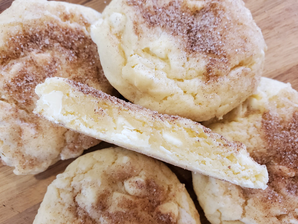 White chocolate snickerdoodle cookies from Let's Get Baked Artisan Desserts, arranged in a dozen on a plate.