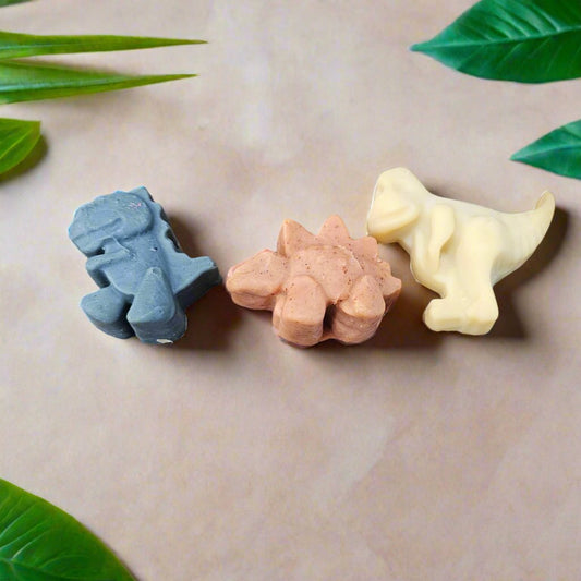 Set of three all-natural, unscented Dino Soap toddler novelty soaps by Soaplicity, shaped like friendly dinosaur figures.